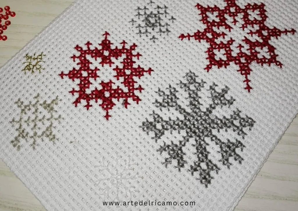 cartolina natalizia con fiocchi di neve ricamati a punto croce
