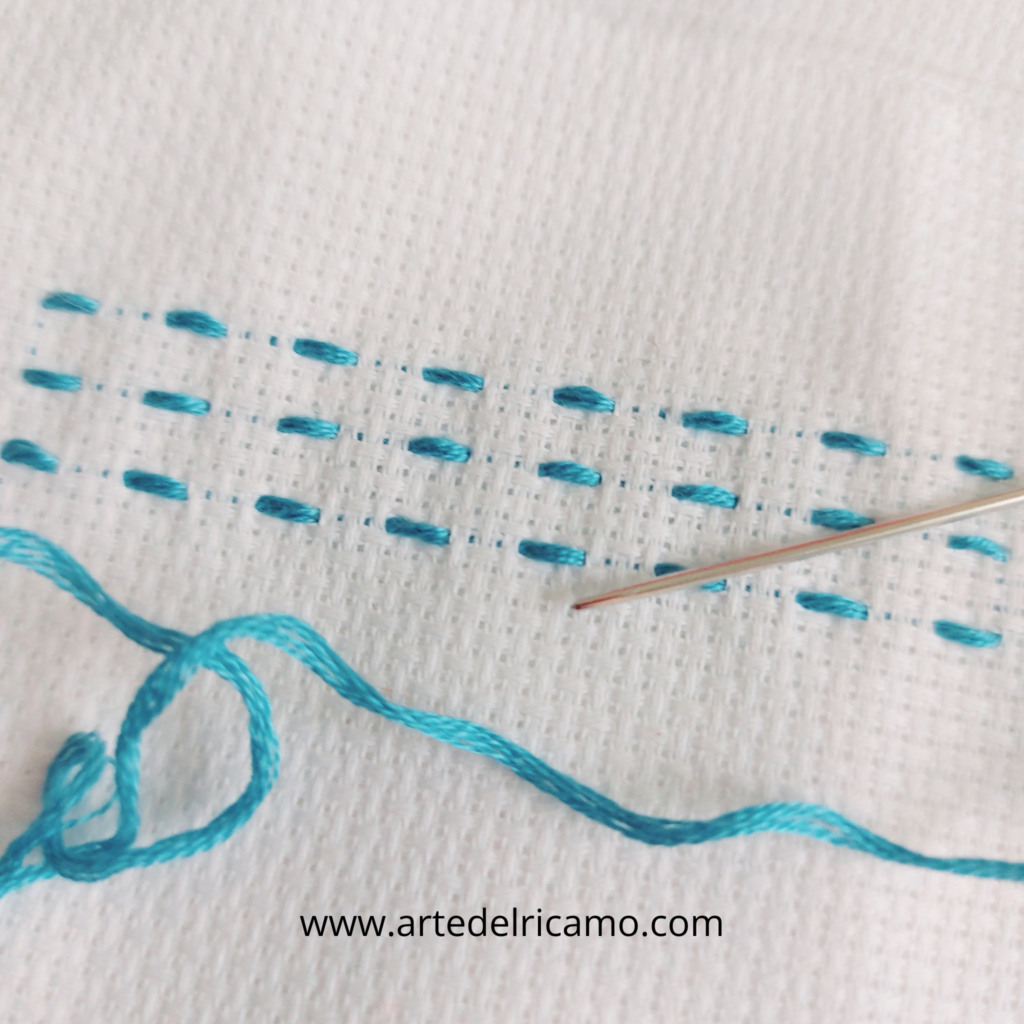 Ago con filo celeste su tela aida.