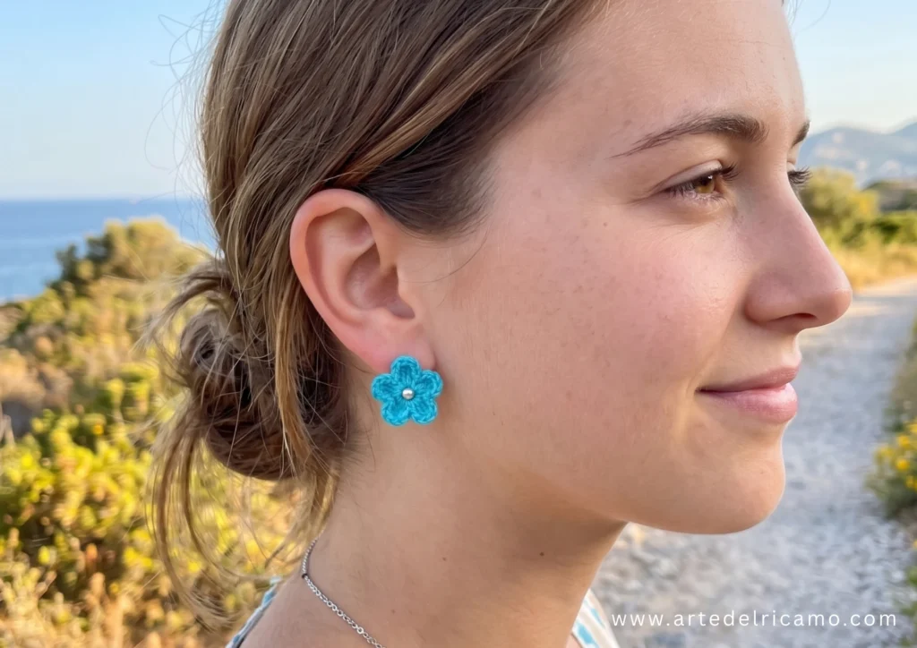 ragazza indossa orecchini con fiori turchesi a uncinetto
